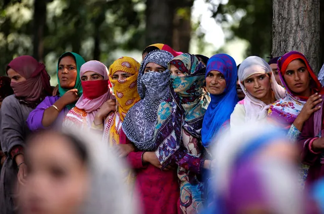 Women watch as people carry the body of Ayub Lelhari, a suspected militant commander, who according to local media was killed in an encounter with the Indian security forces, during his funeral in Lelhar village in Pulwama district, August 17, 2017. (Photo by Danish Ismail/Reuters)