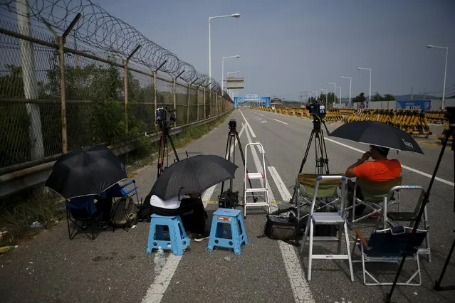 Journalists wait for vehicles transporting South Korean delegation at a checkpoint on the Grand Unification Bridge which leads to the truce village Panmunjom, just south of the demilitarized zone separating the two Koreas, in Paju, South Korea, August 24, 2015. (Photo by Kim Hong-Ji/Reuters)