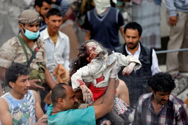 A medic holds the body Ayah Muhammad Mansour, 7, recovered from under the rubble of a house destroyed by a Saudi-led air strike in Sanaa, Yemen August 25, 2017. Her sister Buthaina Muhammad Mansour survived the air strike. Eight family members were killed, relatives said. (Photo by Khaled Abdullah/Reuters)