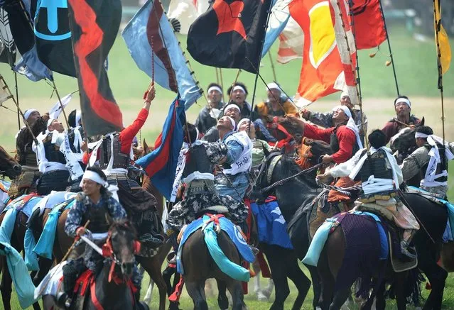 Local people in samurai armor ride their horses as they try to catch a yellow sacred flag (not pictured) at the annual Soma Nomaoi Festival in Minamisoma, Fukushima Prefecture, on July 29, 2012. Some 400 horses and thousands of people took part in the 1,000-year-old “Soma Nomaoi”, or wild horse chase, at the weekend in the shadow of Japan's crippled Fukushima nuclear plant. (Photo by Toru Yamanaka/AFP Photo)