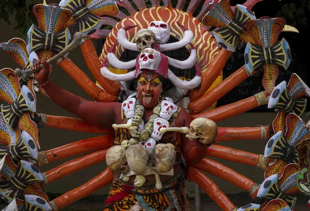 An Indian artist dressed as Hindu goddess Mahakali performs during a procession marking “Bonalu” festival in Hyderabad, India, Monday, July 25, 2022. (Photo by Mahesh Kumar A./AP Photo)