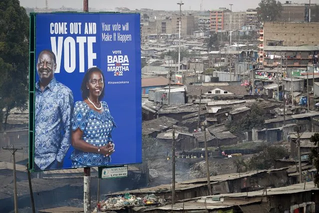 A billboard asking Kenyans to vote for Kenyan presidential candidate Raila Odinga, referred to affectionately as “Baba”, the Swahili word for “father”, and his running mate Martha Karua, rises above shacks in the low-income Mathare neighborhood of Nairobi, Kenya Friday, July 29, 2022. Kenya's Aug. 9 election is ripping open the scars of inequality and corruption as East Africa's economic hub chooses a successor to President Uhuru Kenyatta. (Photo by Brian Inganga/AP Photo)