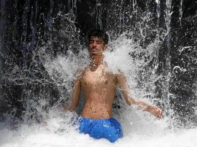 A man cools off under a waterfall in Kabul, Afghanistan June 14, 2016. (Photo by Mohammad Ismail/Reuters)
