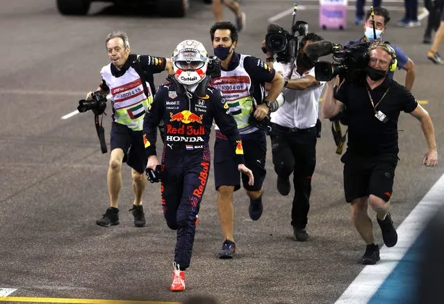 2021 FIA Formula One World Champion Red Bull's Dutch driver Max Verstappen celebrates in the parc ferme of the Yas Marina Circuit after winning the Abu Dhabi Formula One Grand Prix on December 12, 2021. Max Verstappen became the first Dutchman ever to win the Formula One world championship title when he won a dramatic season-ending Abu Dhabi Grand Prix. (Photo by Hamad I Mohammed/Reuters)