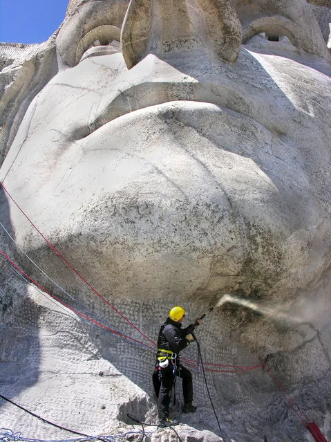 A man cleans a part of Mount Rushmore in South Dakota. (Photo by Caters News Agency)