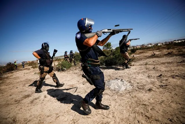 Police fire shotguns and teargas as they attempt to disperse Khayelitsha township residents trying to erect shacks on open ground during a nationwide lockdown aimed at limiting the spread of the coronavirus disease (COVID-19), in Cape Town, South Africa on April 21, 2020. (Photo by Mike Hutchings/Reuters)