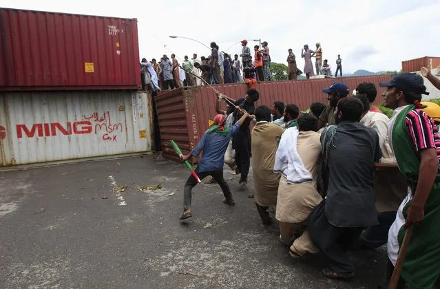 Anti-government protesters pull a rope to remove a container barricade during the Revolution March in Islamabad September 2, 2014. Pakistani protesters pushed closer to the prime minister's house in central Islamabad on Monday in their bid to force his removal and forced national television off the air after clashes turned violent over the weekend. (Photo by Akhtar Soomro/Reuters)