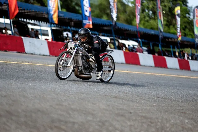 This photo taken on September 11, 2022 shows a Thai drag racer racing his modified motorbike during the NGO Street Drag Race event in Thailand's Chonburi province. (Photo by Manan Vatsyayana/AFP Photo)
