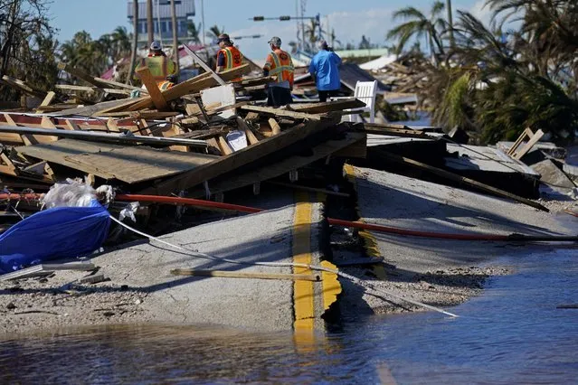 Responders from the de Moya Group survey damage to the bridge leading to Pine Island, to start building temporary access to the island in the aftermath of Hurricane Ian in Matlacha, Fla., Sunday, October 2, 2022. The only bridge to the island is heavily damaged so it can only be reached by boat or air. (Photo by Gerald Herbert/AP Photo)