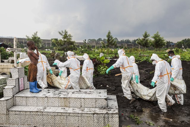 A child standing on a grave watches as members of the Congolese Red Cross and volunteers carry victims of the recent conflict in a cemetery in Goma, Democratic Republic of the Congo, 04 February 2025. (Photo by EPA/EFE/Stringer)
