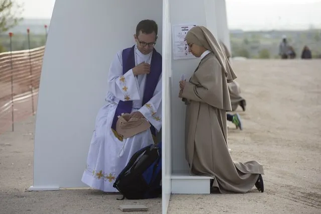 A nun confesses while waiting for the beginning of a beatification ceremony in Madrid, Spain, Saturday September 27, 2014. Some thousands of Catholics from around the world attended the open air beatification ceremony of Opus Dei Bishop Alvaro del Portillo, the 2nd most important figure in the order after founder Jose Maria Escriva. (Photo by Santi Palacios/AP Photo)