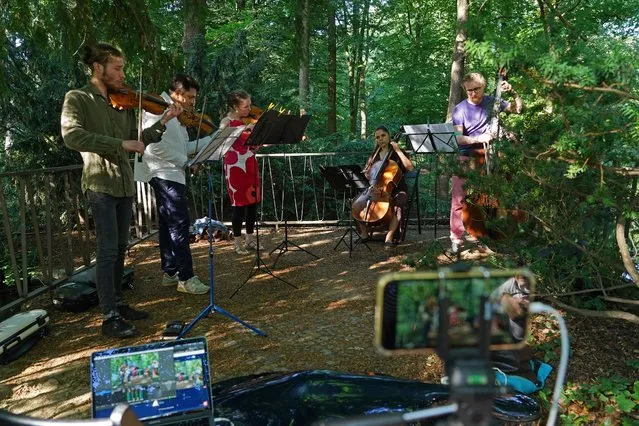 A string quintet led by cellist Elisabet Iserte-Lopez performs in a livestream from Tiergarten Park for Fete de la Musique during the novel coronavirus pandemic on June 21, 2020 in Berlin, Germany. Musicians participating in the annual Fete de la Musique usually perform open-air, though this year, due to the pandemic, most performances are taking place indoors and all are being livestreamed. (Photo by Sean Gallup/Getty Images)
