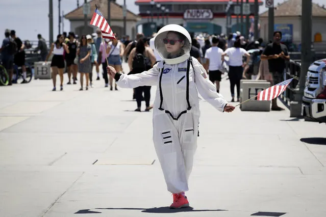 A visitor wears a space suit costume on the pier Saturday, June 27, 2020, in Huntington Beach, Calif. (Photo by Marcio Jose Sanchez/AP Photo)
