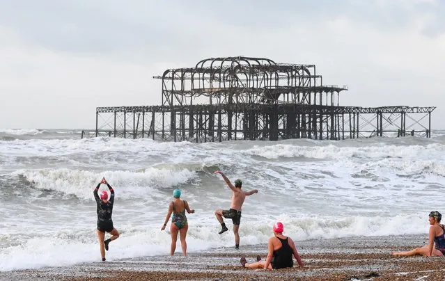 Members of the iSWIM community of sea swimmers in Brighton take a bracing early morning dip near the West Pier on November 1, 2022 after a night of strong winds and rain brought by Storm Claudio in the UK. (Photo by Simon Dack/Alamy Live News)