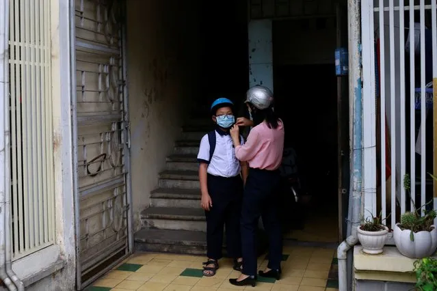 Do Thi Kim Dung, 41, and her son Nguyen Dinh Thanh, 11, get ready at home before his first day back to primary school after the government eased nationwide lockdown during the coronavirus disease (COVID-19) outbreak in Ho Chi Minh, Vietnam on May 8, 2020. (Photo by Yen Duong/Reuters)