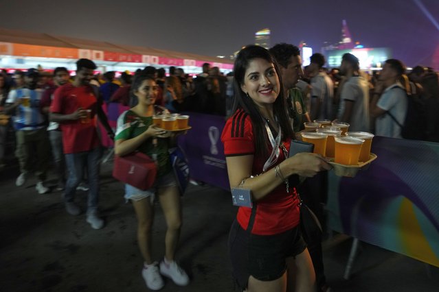 Fans carry their beers at a fan zone ahead of the FIFA World Cup, in Doha, Qatar Saturday, November 19, 2022. (Photo by Petr David Josek/AP Photo)