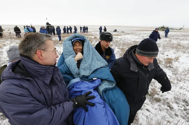 Ground personnel carry International Space Station (ISS) crew member Reid Wiseman of the U.S. shortly after landing near the town of Arkalyk in northern Kazakhstan, November 10, 2014. (Photo by Shamil Zhumatov/Reuters)