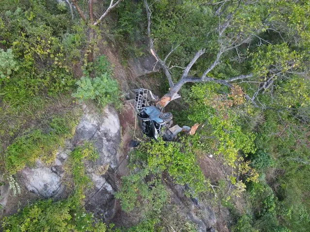This aerial view shows a crashed pickup truck at the bottom of a ravine in Conacaste village, Jocotan municipality, Guatemala, on October 5, 2022. At least 17 people were killed and 13 injured when a pickup truck plunged off a cliff in eastern Guatemala on Wednesday, a local official said. (Photo by Carlos Alonzo/AFP Photo)