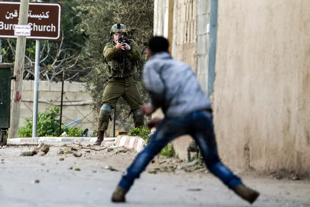 A Palestinian protester confronts an Israeli soldier during an army search operation in the Palestinian village of Burqin in the northern occupied West Bank, on February 3, 2018. (Photo by Jaafar Ashtiyeh/AFP Photo)
