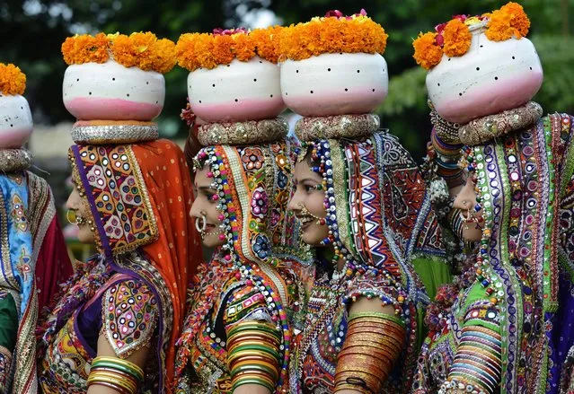 Indian folk dancers from the Panghat Group of Performing Arts pose for a photograph during a dress rehearsal for an event to mark the forthcoming Hindu festival “Navaratri”, or the Festival of Nine Nights, in Ahmedabad on September 25, 2016. The Navaratri festival begins on October 1. (Photo by Sam Panthaky/AFP Photo)