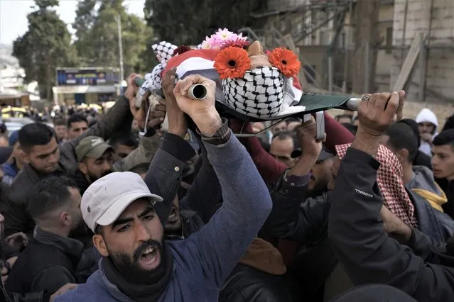 Palestinian mourners carry the body of Ahmad Kahla, 45, during his funeral in the West Bank village of Rammun, Sunday, January 15, 2023. The Palestinian Health Ministry says Israeli troops have shot and killed the Palestinian man in the occupied West Bank. The Israeli military said troops opened fire when a passenger in a suspicious vehicle tried to grab a soldier's weapon. (Photo by Majdi Mohammed/AP Photo)