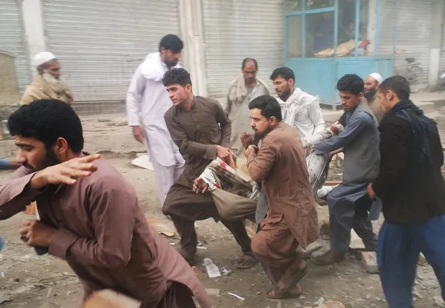 Afghan men carry an injured man after a blast in Jalalabad, Afghanistan February 20, 2018. At least three people were killed and two others injured. (Photo by Reuters/Parwiz)