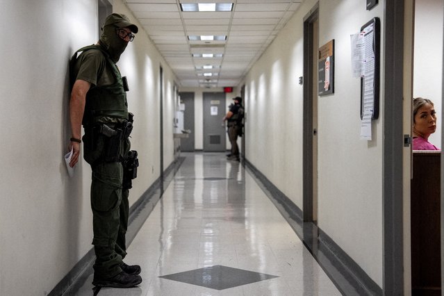 A federal immigration officer waits outside of a courtroom at a U.S. immigration court in Manhattan, in New York City on August 7, 2025. (Photo by David Dee Delgado/Reuters)