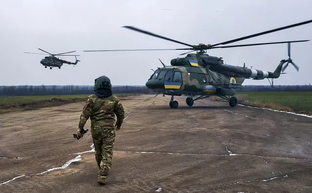 A pilot approaches his helicopter at a Ukrainian military air base close to the frontline in the Kherson region, Ukraine, Sunday, January 8, 2023. (Photo by LIBKOS/AP Photo)