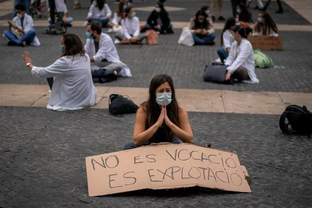Medical residents take part on a protest against their working conditions during a strike in Barcelona, Spain, Thursday, October 22, 2020. Spain has reported 1 million confirmed infections — the highest number in Western Europe — and at least 34,000 deaths from COVID-19, although experts say the number is much higher since many cases were missed because of testing shortages and other problems. Banner reads in Spanish: “it is not a vocation but exploitation”. (Photo by Emilio Morenatti/AP Photo)