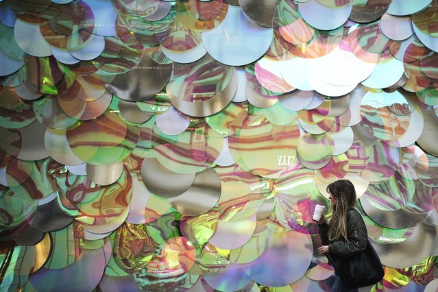 A woman walks by a temporary shopping pavilion decorated with giant sequins in Moscow, Wednesday, July 2, 2025. (Photo by Pavel Bednyakov/AP Photo)