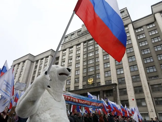 A participant dressed as a polar bear carries a Russian national flag as he marches past the State Duma during a demonstration on National Unity Day in Moscow, Russia November 4, 2015. (Photo by Sergei Karpukhin/Reuters)