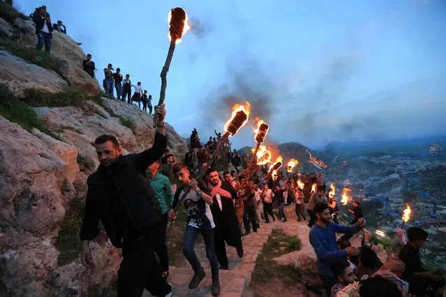 Iraqi Kurdish people carry fire torches up a mountain, as they celebrate Newroz Day, a festival marking their spring and new year, in the town of Akra, Iraq on March 20, 2018. (Photo by Ari Jalal/Reuters)