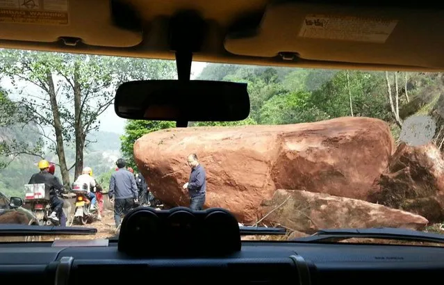 In this photo provided by China's official Xinhua News Agency, a giant rock blocks the road, about 20 kilometers (12.5 miles) from the county seat of Lushan in Ya'an city, southwest China's Sichuan Province, Saturday, April 20, 2013. A powerful earthquake jolted China's Sichuan province Saturday near where a devastating quake struck five years ago. (Photo by Hai Mingwei/AP Photo/Xinhua)