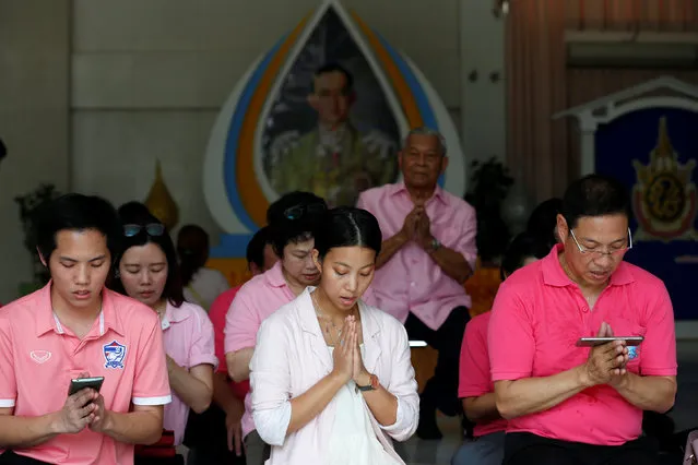 Well-wishers wear pink shirts as they pray in front of a picture of Thailand's King Bhumibol Adulyadej at Siriraj Hospital in Bangkok, Thailand, October 11, 2016. (Photo by Chaiwat Subprasom/Reuters)