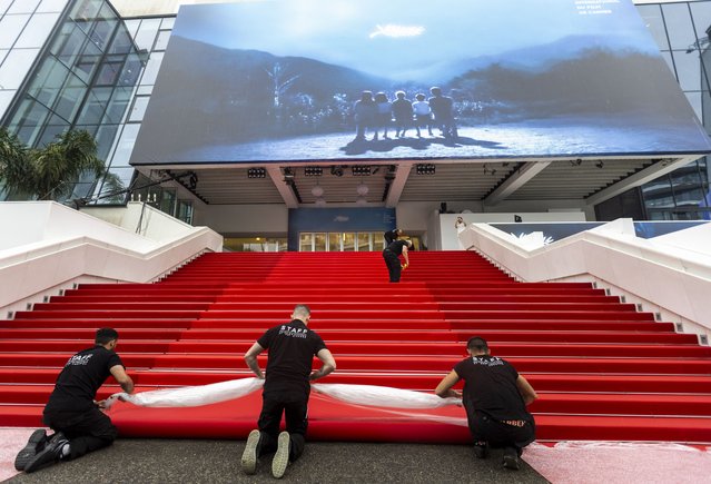 Workers install the red carpet ahead of the opening ceremony of the 77th annual Cannes Film Festival, in Cannes, France, 14 May 2024. The film festival runs from 14 to 25 May 2024. (Photo by Andre Pain/EPA)