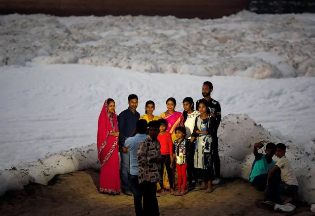 A family gets their picture taken in front of the foam covering the polluted Yamuna river in New Delhi, India October 11, 2016. (Photo by Adnan Abidi/Reuters)