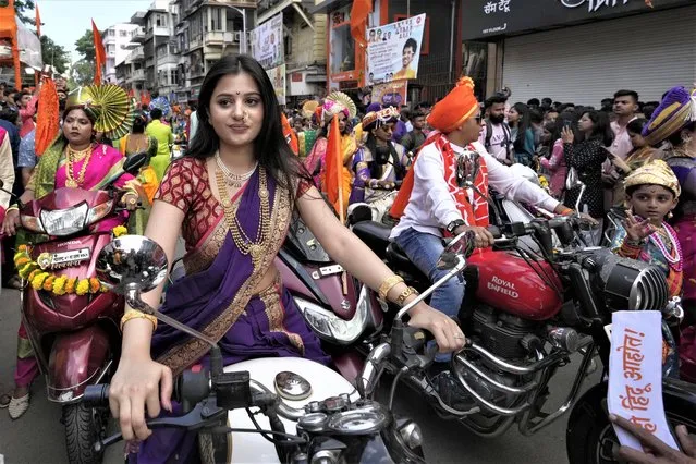 An Indian woman dressed in traditional attire rides a motorcycle as she participates in a procession to mark Gudi Padwa or the Marathi New Year in Mumbai, Maharashtra state, India, Wednesday, March 22, 2023. (Photo by Rajanish Kakade/AP Photo)