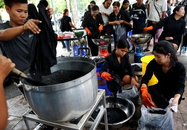 Volunteers offer free services to help dye mourners' shirts black outside the Grand Palace in Bangkok, Thailand October 17, 2016. (Photo by Edgar Su/Reuters)