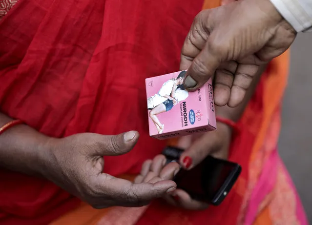 An Indian sеx worker receives a free condom packet during an awareness rally on World AIDS Day, organized by the Durbar Mahila Samanwaya Committee in the Sonagachi red light district, in Kolkata, India 01 December 2020. World AIDS Day is annually observed on 01 December with calls from international health and advocacy organizations for the public to get involved in programs for awareness, prevention and treatment of Human immunodeficiency virus infection and acquired immune deficiency syndrome (HIV/AIDS). (Photo by Piyal Adhikary/EPA/EFE)