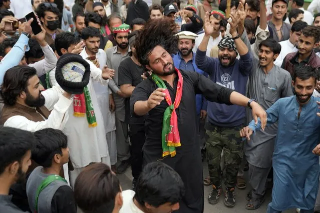 Supporters of former Prime Minister Imran Khan dance outside of the Khan house in Lahore, Pakistan, Sunday, March 19, 2023. Police in the Pakistani capital filed charges Sunday against former Prime Minister Imran Khan and 17 of his aides and scores of supporters, accusing them of terrorism and several other offenses after the ousted premier's followers clashed with security forces in Islamabad the previous day. (Photo by K.M. Chaudary/AP Photo)