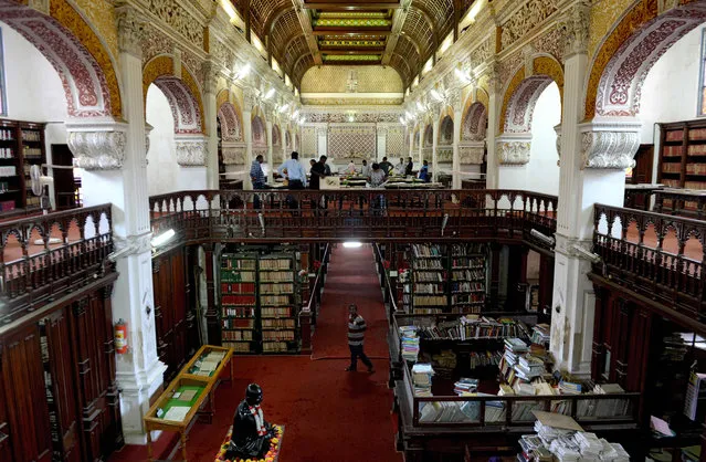 Indian visitors look at books displayed at one of India' s oldest “Connemara” library during an open for the public on the occasion of world book day in Chennai on April 23, 2018. World Book Day is a observed on April 23 rd and is organized by the United Nations Educational, Scientific and Cultural Organization (UNESCO) to promote reading. (Photo by  Arun Sankar/AFP Photo)
