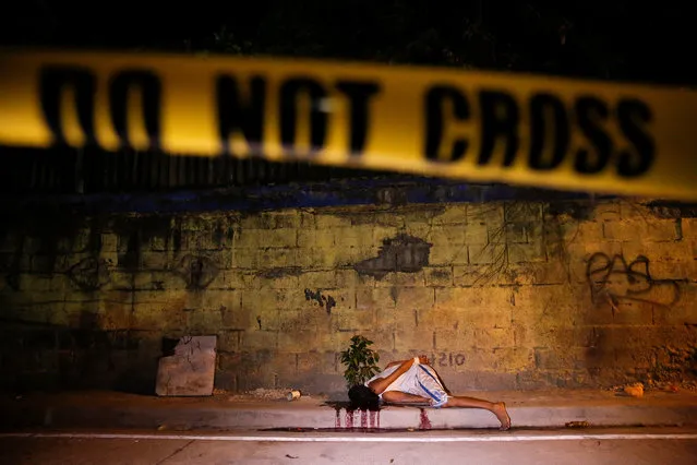 A police line is placed around the body of a man killed by unknown gunmen in Manila, Philippines early October 25, 2016. (Photo by Damir Sagolj/Reuters)