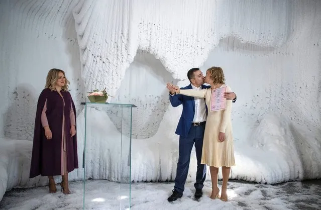 Newlyweds kiss during their wedding ceremony in an ice cave at Zaryadye Park in downtown Moscow, Russia, 25 December 2020. The ice cave has a temperature inside of –10 Celsius degrees. The ice was made in stages, with 70 tonnes of water frozen on the cave's walls. Seven thousand couples have registered their marriage under the Moscow government's marriage registration program in 30 unusual places in the city during 2020. Zaryadye Park is a large-scale project to create a 78,000 square meters public rest space within the Boulevard Ring near the Kremlin. (Photo by Sergei Ilnitsky/EPA/EFE)
