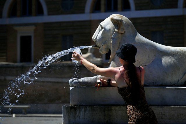 A woman fills her bottle with water at the Lions fountain at Piazza del Popolo on July 12, 2024 in Rome where temperatures are expected to rise to 36 degrees celsius. (Photo by Filippo Monteforte/AFP Photo)