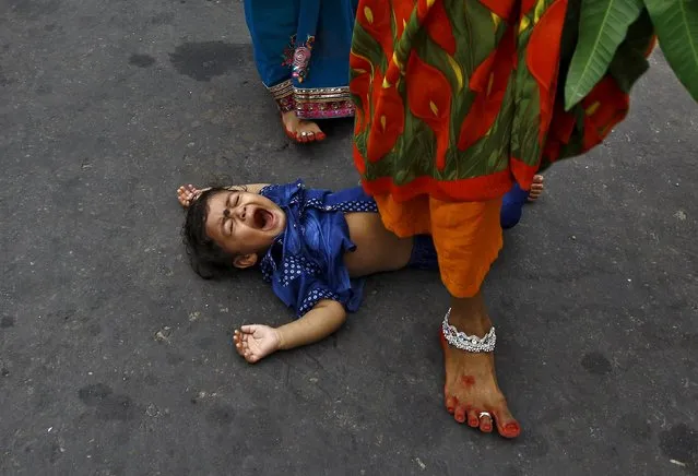 A Hindu woman steps over a child in a ritual seeking blessings for the child from the Sun god Surya during the Hindu religious festival of Chatt Puja in Kolkata, India, November 17, 2015. (Photo by Rupak De Chowdhuri/Reuters)