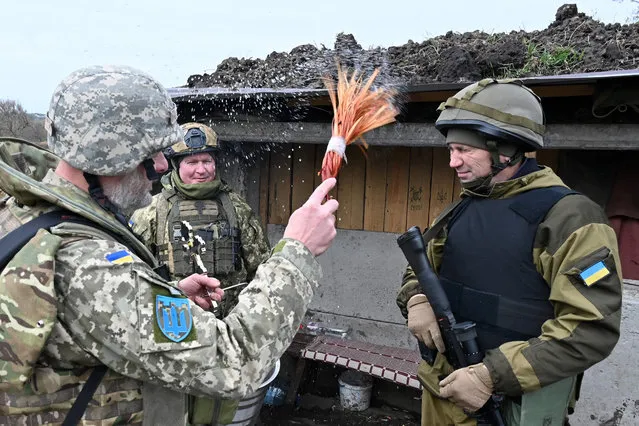 Chaplain Yuriy Potykun blesses soldiers on the eve of Orthodox Easter, at position of Ukrainian troops in Kharkiv region, on April 15, 2023, amid Russia's military invasion on Ukraine. (Photo by Sergey Bobok/AFP Photo)