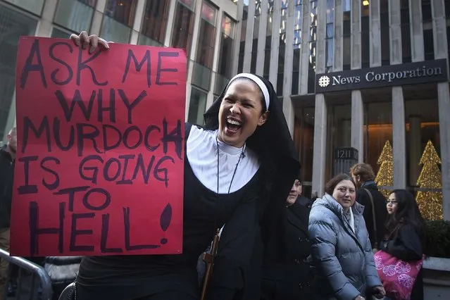 A demonstrator dressed as a nun holds a sign in front of News Corporation's New York office in Manhattan January 2, 2015. Protesters said that its companies, specifically the daily newspaper New York Post and cable news channel Fox News Network, had biased coverage of the recent anti-police brutality rallies. (Photo by Carlo Allegri/Reuters)