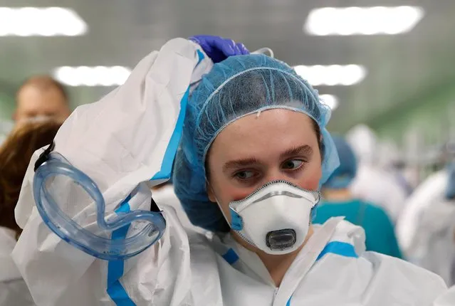 A medical specialist puts on personal protective equipment (PPE) at the City Clinical Hospital Number 15 named after O. Filatov, which delivers treatment to patients infected with the coronavirus disease (COVID-19), in Moscow, Russia on May 25, 2020. (Photo by Maxim Shemetov/Reuters)