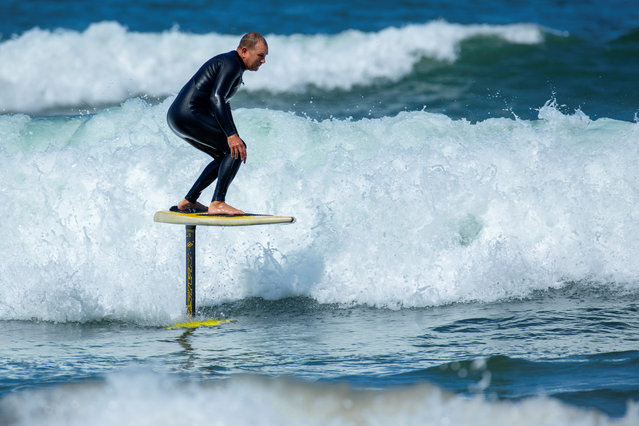 Surfer Gary Clisby rides his foil board on a morning swell of the coast of Carlsbad, California on May 23, 2018. (Photo by Mike Blake/Reuters)