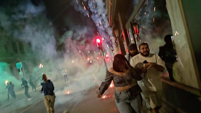 People run amid tear gas during a protest following partial results in the second round of the early French parliamentary elections, in Lyon, France, on July 7, 2024 in this still image obtained from social media video. (Photo by Medave Prod via Reuters)